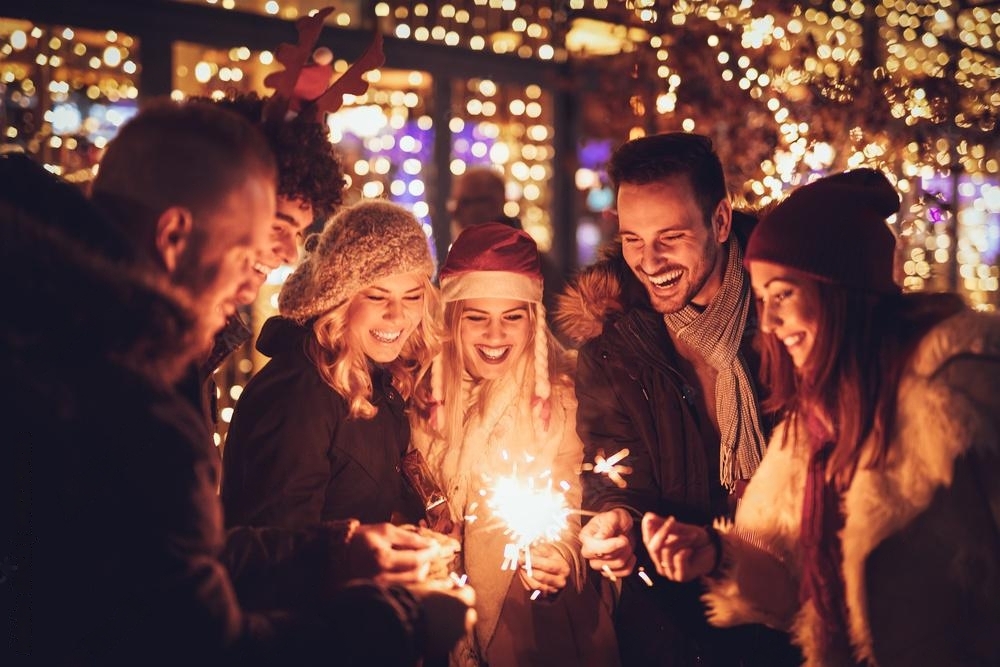 Een feestelijk kerstfeest op het werk met werknemers die vieren onder kerstlichtjes en decoraties.